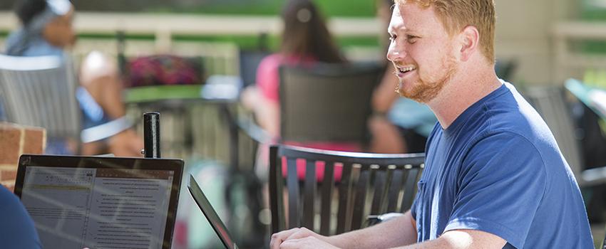 Student working on laptop outside